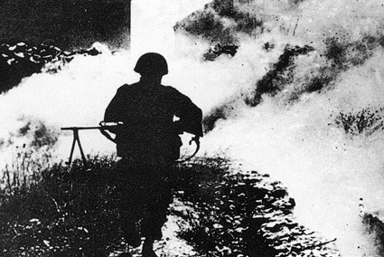 תמונה בשחור לבן של חייל צה"ל רץ בקרב על גבעת התחמושת
