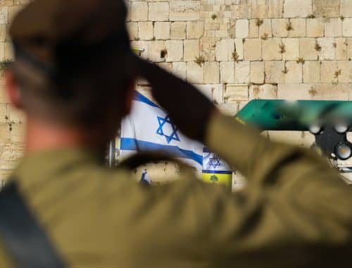 חייל צה"ל מצדיע למול הכותל ודגל ישראל