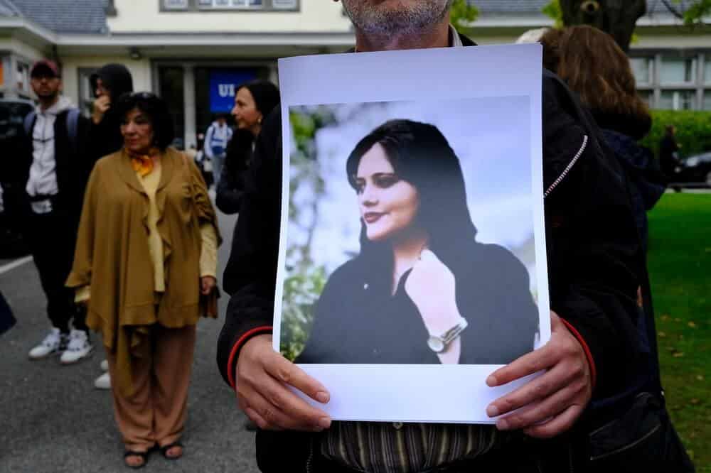 A protester holding a picture of Mahsa Amini