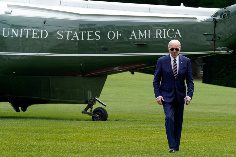 Joe Biden with sunglasses walking away from helicopter