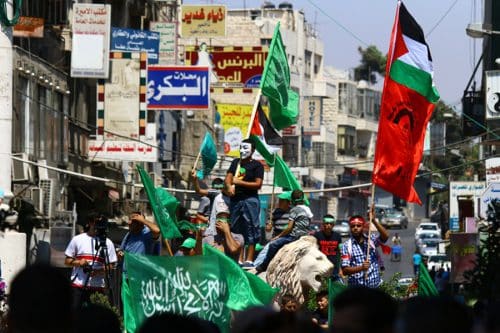 נערים פלסטינים מנופפים בדגלי חמאס ברחובות רמאללה
