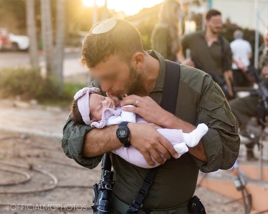 Israeli soldier holding a baby