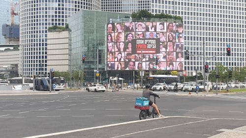 שלט גדול של תמונות חטופים מעל כניסה לעזריאלי ת"א