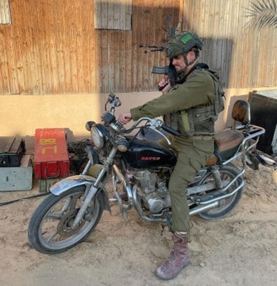 An Israeli soldier from the Paratroopers’ 55th Brigade posing with a motorcycle used by Hamas’ Nukhba unit, probably used on October 7 and found in a Gaza home | Photo: Afik Rosner