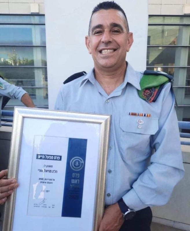 Officer Uri Moyal Holding a Lifetime Achievement Award certificate