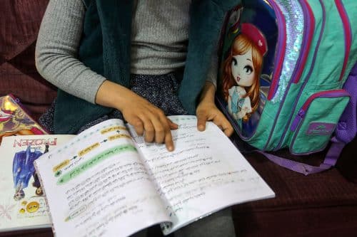 תלמידה פלסטינית קוראת בחוברת לימוד בערבית עם סימני מארקר