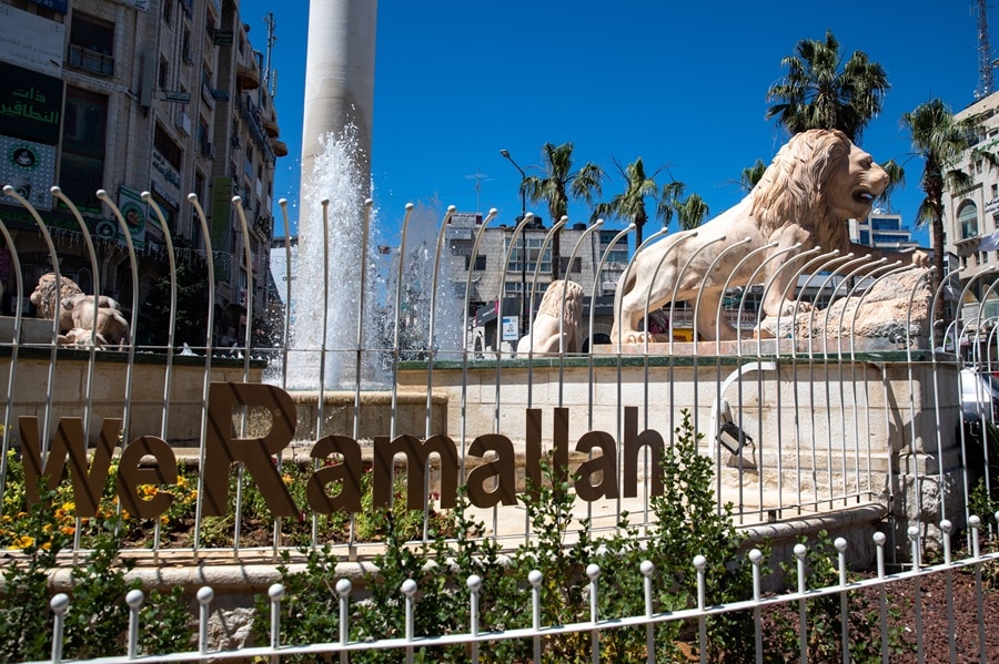 fenced fountain in ramalla with lion statue