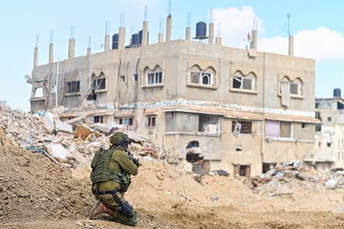 IDF soldier near dilapidated house in Han Yunis