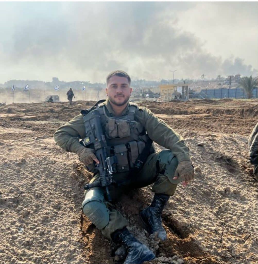 Nisim Kachlon z"l with military vest and m16 sitting on ground 