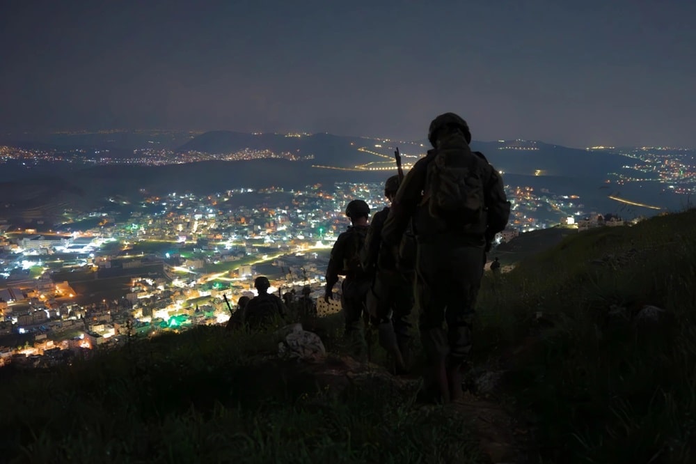 IDF soldiers at night overlooking Nablus city lights from the hill