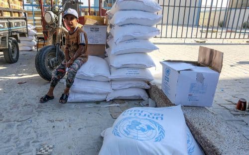 Palestinians come to receive food aid from a United Nations Relief and Works Agency (UNRWA)