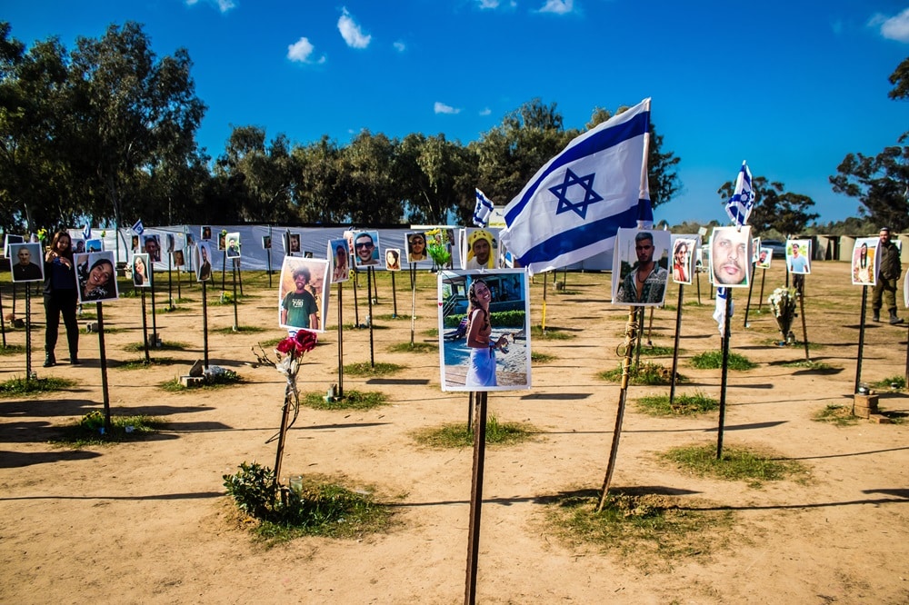 עמודים עם תמונות הנרצחים והחטופים ודגלי ישראל באתר מסיבת הנובה