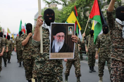 Revolutionary Guards soldier holding leaders photo