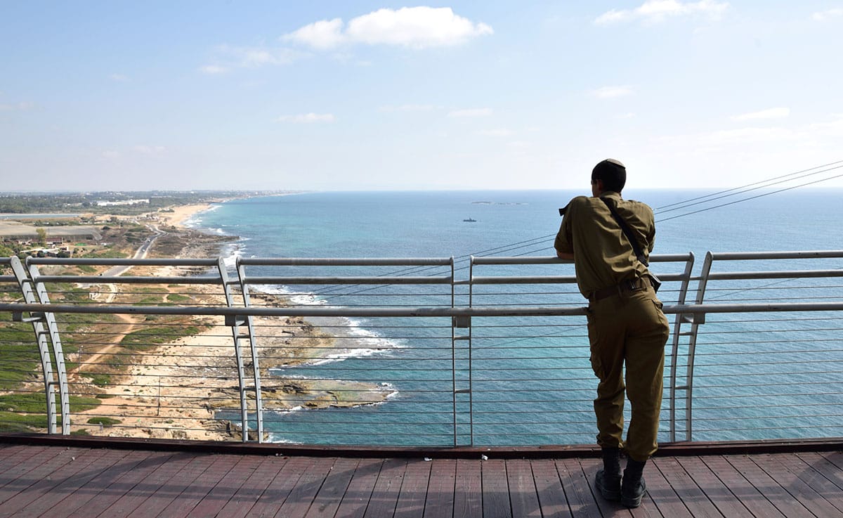 חייל בטיילת מביט בים