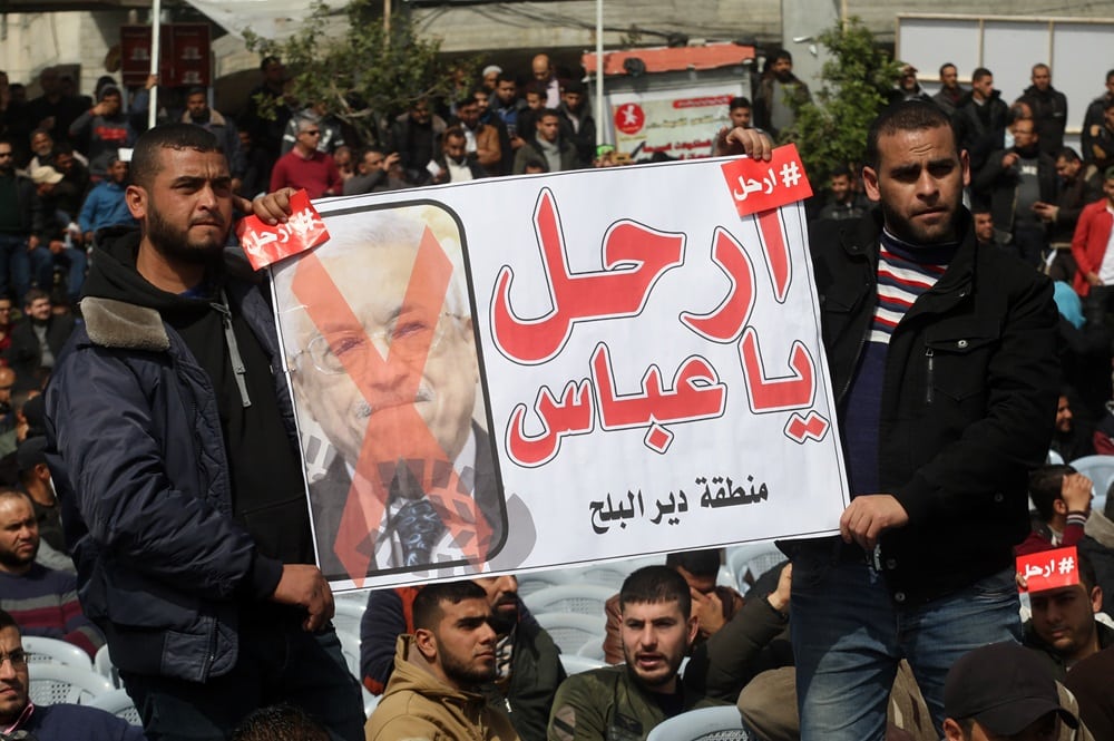 demonstrators holding Abu Mazen photo marked with X