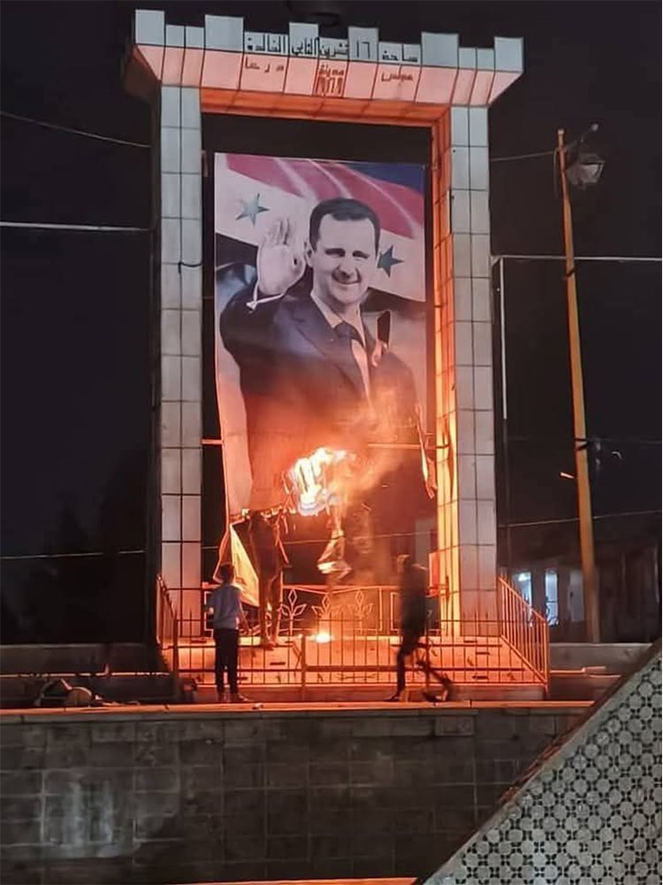 large Assad picture being burned