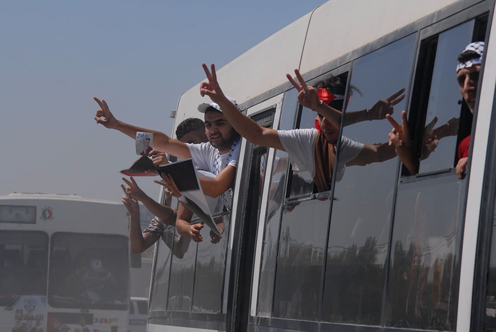 released prisoners make V signs from bus windows