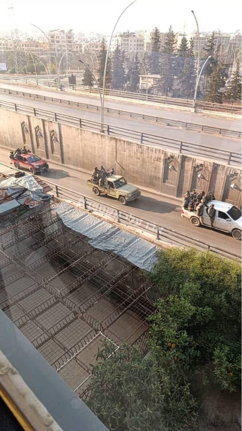 row of jeeps with rebels on road