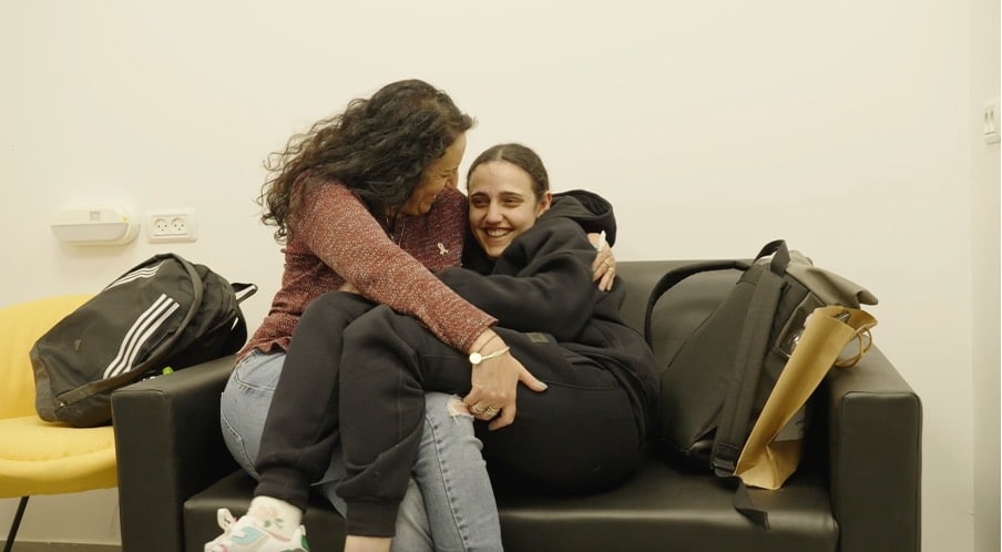 Romi smiling on couch with her mom