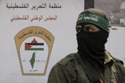 כרזה של אש"ף עם פעיל פלסטיני חמוש ברקע, המסמלת את הקמת הארגון לשחרור פלסטין בשנת 1964